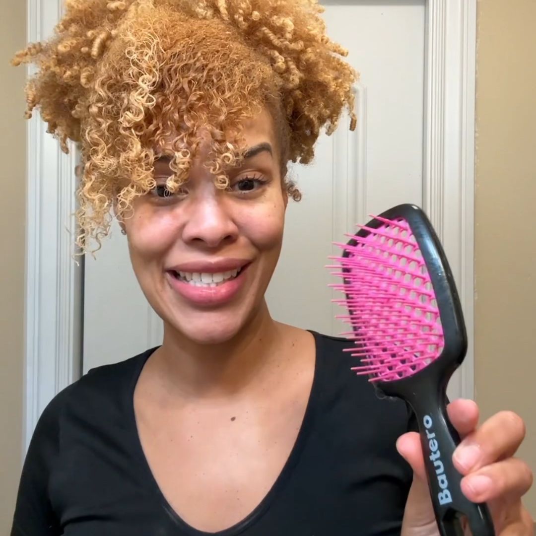 woman-holding-up-the-bautero-brush-for-detangling-curly-hair